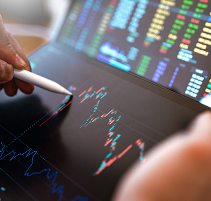 Trader analyzing charts and market data on a screen